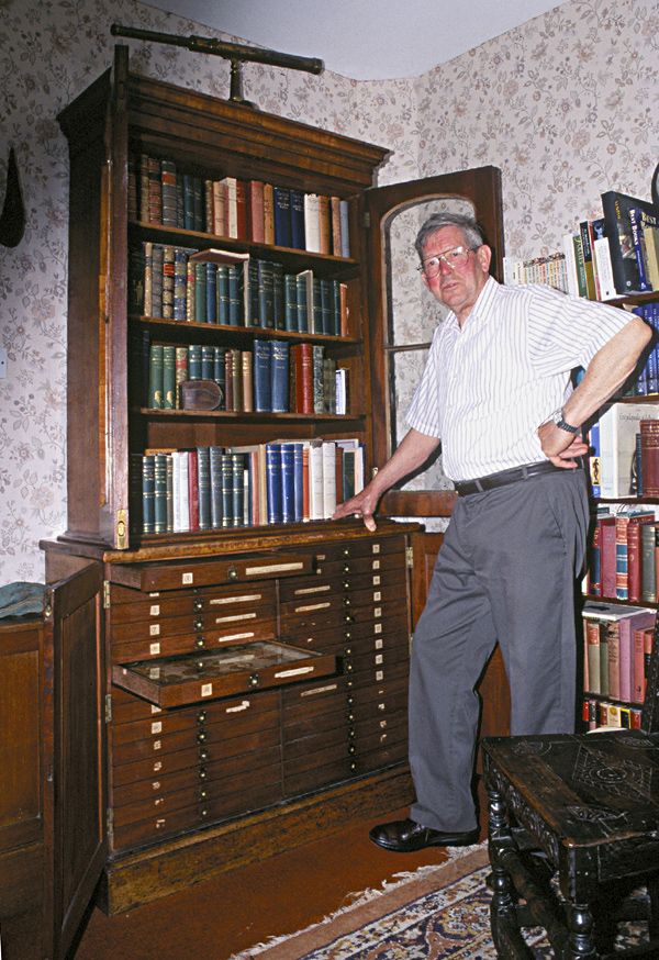 Richard Wallace with his grandfather's insect cabinet and book collection